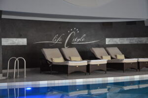 Schwimmbad mit Relaxliegen im Hotel Cervosa