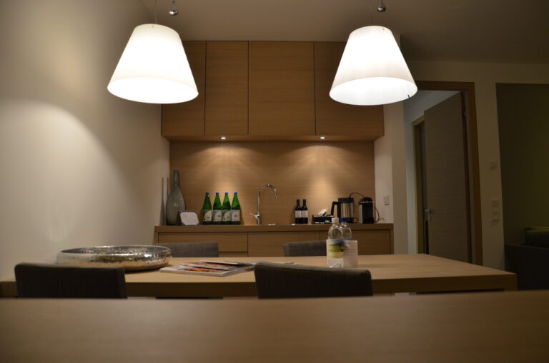 Blick in eine offene Küche mit Sitzgelegenheit im Golfhotel Suites